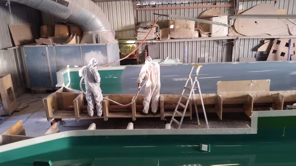 La fabrication du 4X commence par l'application dans le moule du gelcoat gris caractéristique. Le bateau est identique au 45', mais bénéficie de cloisons et d'un pont carbone.